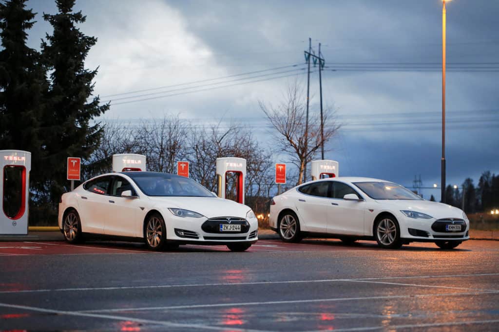 PAIMIO, FINLAND - NOVEMBER 14, 2015: Two white Tesla Model S cars are being charged at Tesla Supercharger station at night. Tesla Supercharging stations charge up to 16 times as fast as public charging stations.