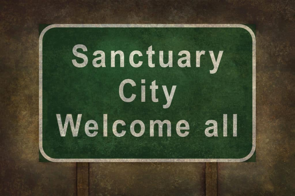 Sanctuary city welcome road sign illustration with distressed foreboding background