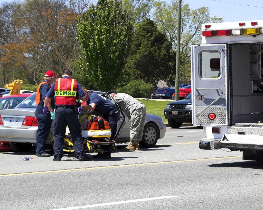 Two cars meet in the center turn lane 3 people taken to hospital by ambulancesoldiers helping medics