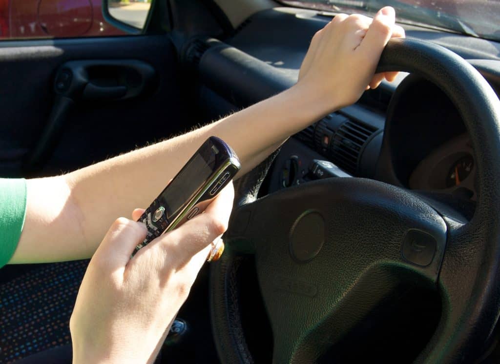 Woman driving while making a text message