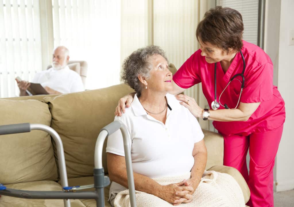 Senior woman in a nursing home with a caring nurse.