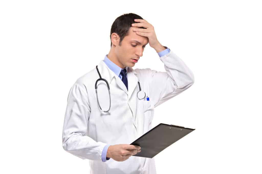 A doctor banging his head realizing a mistake he forgot isolated on white background