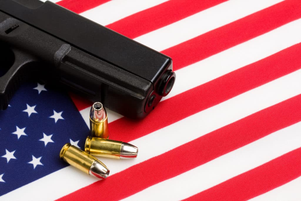 gun over american flag modern 9mm handgun with bullets