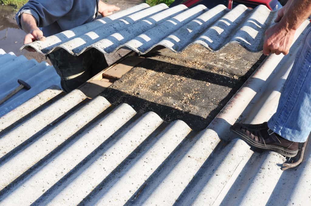 Asbestos workers repair asbestos roof. Asbestos removal.