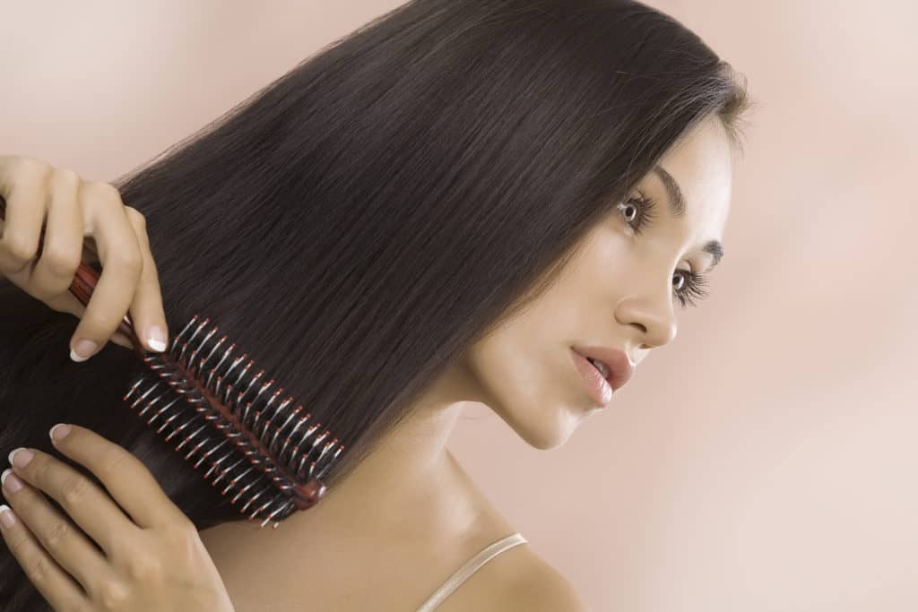 Portrait of nice young woman getting busy with her hair