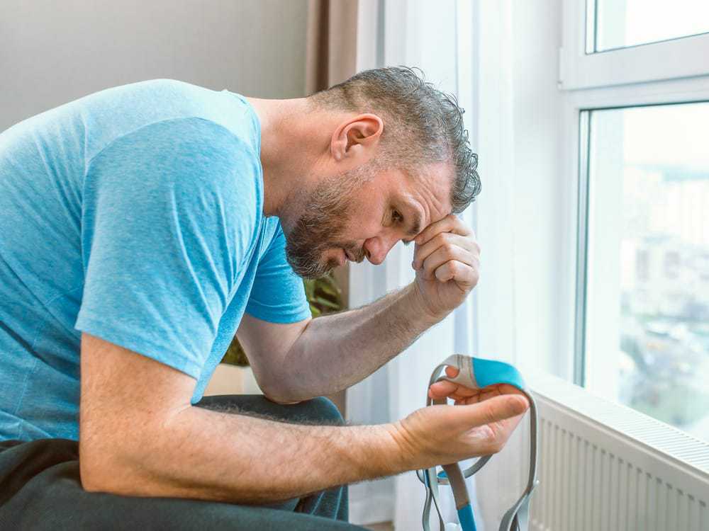 man looking at CPAP medical device