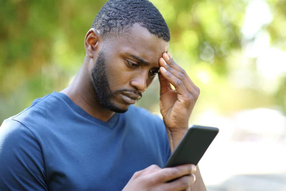 worried man checking smartphone