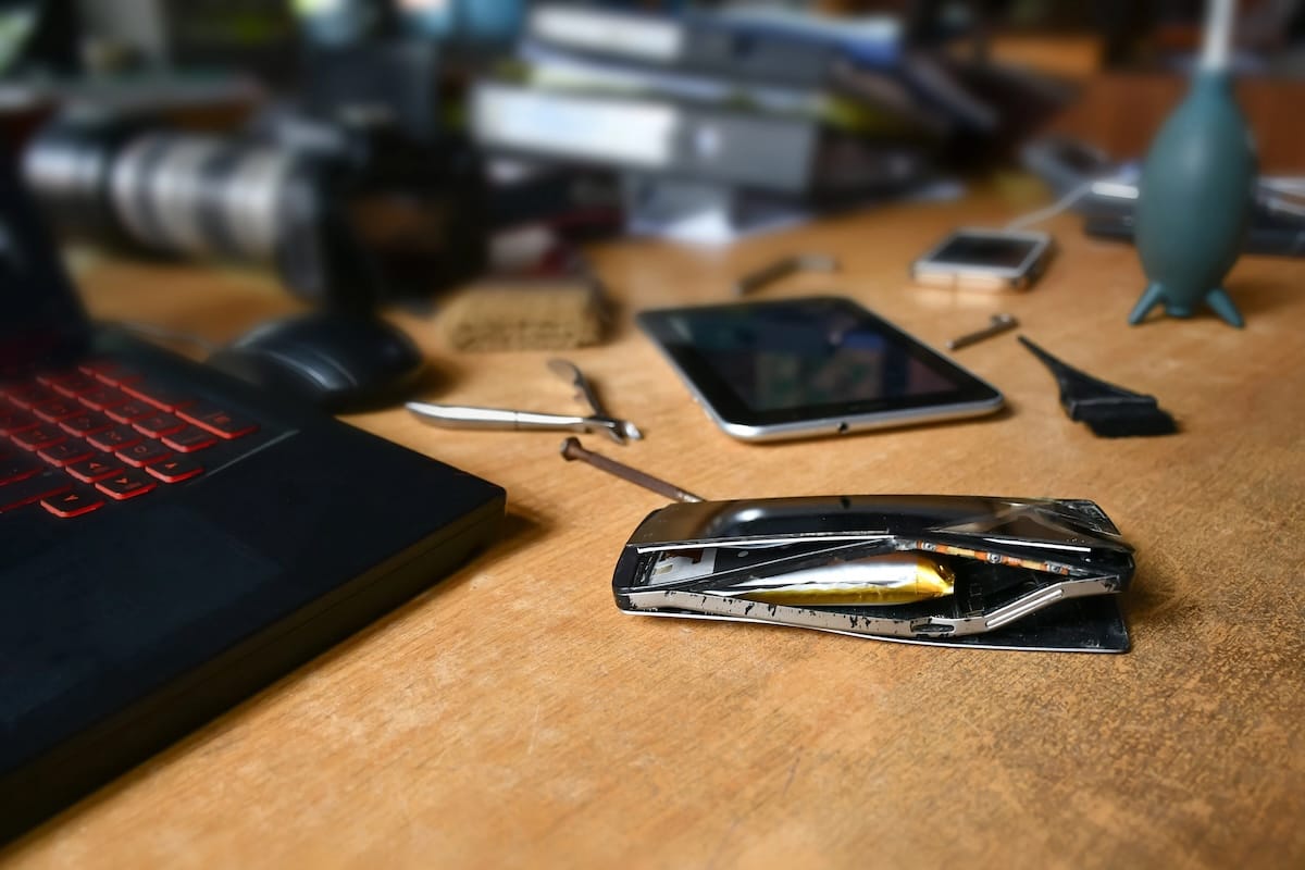 exploded battery on cell phone sitting on a workbench