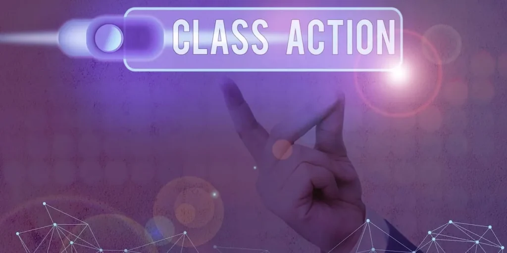Hand pressing a glowing Class Action switch on a purple background
